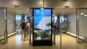 Die Bilder sind am Flughafen Genf und zeigen ein digitaler Screen. Der digitale Screen zeigt die Werbung vom Resort The Ellinikon an. 
The pictures are taken at Geneva Airport and show a digital screen. The digital screen shows the advertisement of the resort The Ellinikon.