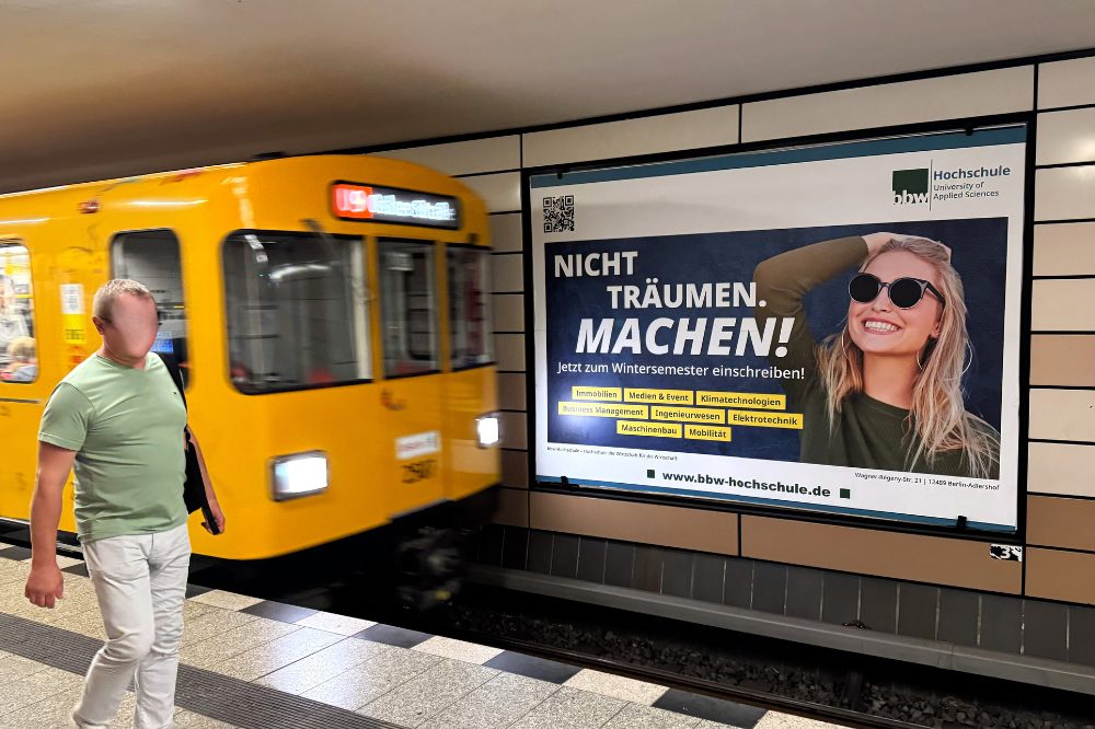 BBW Plakatwerbung. An U-Bahnhof Bundesplatz in Berlin, hängt auf einer Großfläche hinter den Gleisen eine Plakatwerbung der BBW Hochschule die für das diesjährige Wintersemester wirbt. und. Der Slogan „NICHT TRÄUMEN. MACHEN!“ soll zum Einschreiben bewegen. Auf dem Plakat sieht man neben den verschiedenen Studiengängen auch eine lässige Frau mit Sonnenbrille, die Ihre Zukunft im Griff hat. Links vom Plakat fährt gerade die gelbe U-Bahn der Linie U9 ein und auf dem Bahnsteig lauft ein Mann.