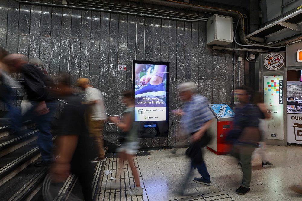 A digital city light poster at a train station in Barcelona. The digital advertisement shows the trade fair shoptalk.