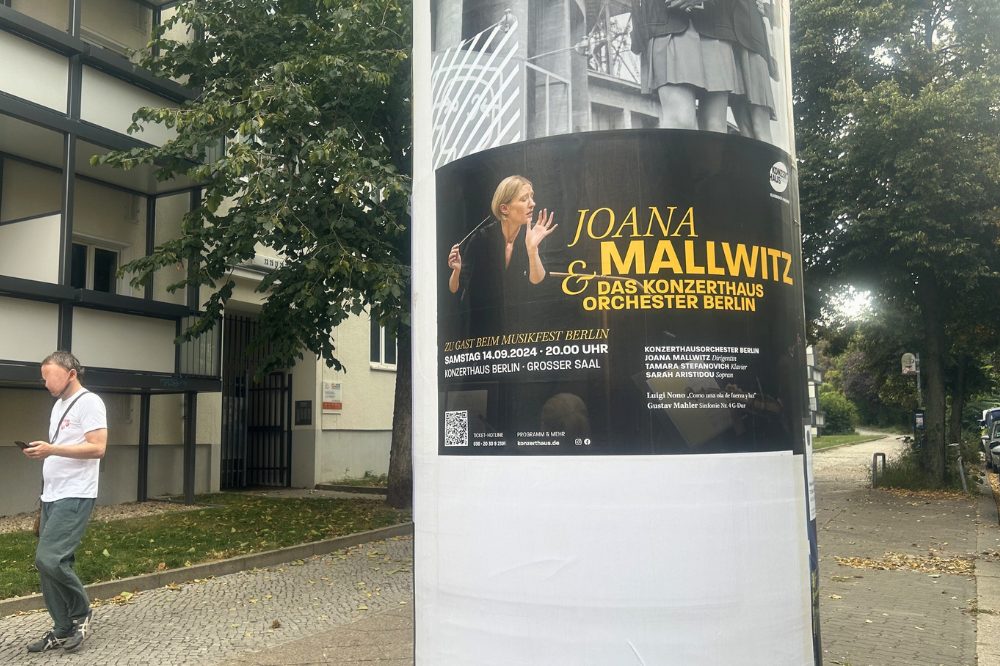 Das Bild zeigt eine Säule an der Greifswalder Straße, auf der Werbung für das Konzerthaus angebracht ist. The image shows a pillar on Greifswalder Street with an advertisement for the concert hall.