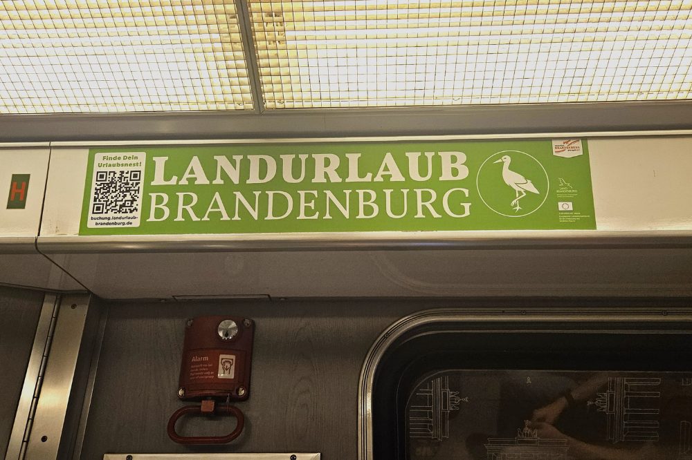In einer U-Bahn hängt über dem Fenster eine grüne Werbefolie im Format Seitenstreifen, mit der Aufschrift „Landurlaub Brandenburg“. Mit dieser Innenwerbung soll der ländliche Raum der Region Berlin-Brandenburg gestärkt werden. Side strip in the Berlin subway. It displays advertising from ProAgro.