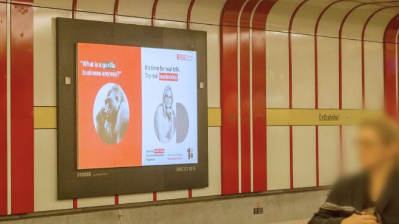 Infoscreen auf dem Ostbahnhof in München. Es zeigt die Imagewerbung von der Hochschule IESE Business School. An info screen at Ostbahnhof station in Munich displays an advertisement for IESE Business School.